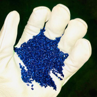 ARPMAX blue polymer granules held in a gloved hand